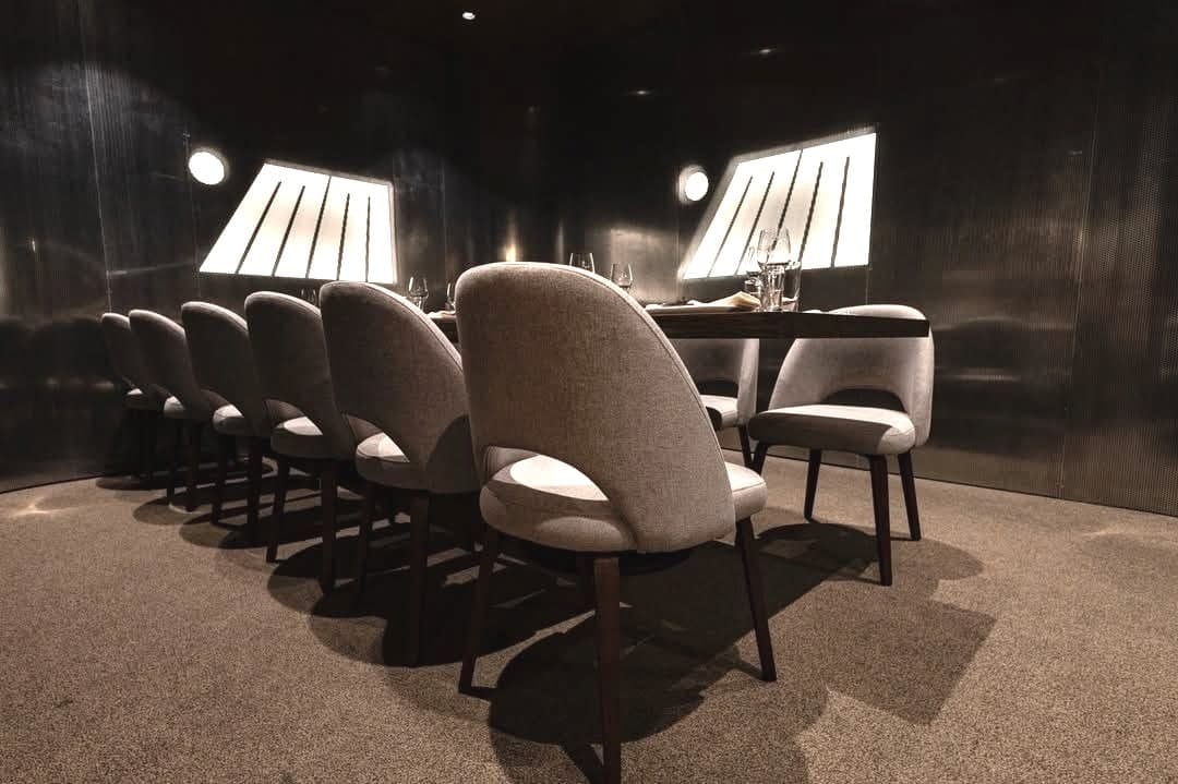 Private dining room in silver perforated steel with custom LED signage