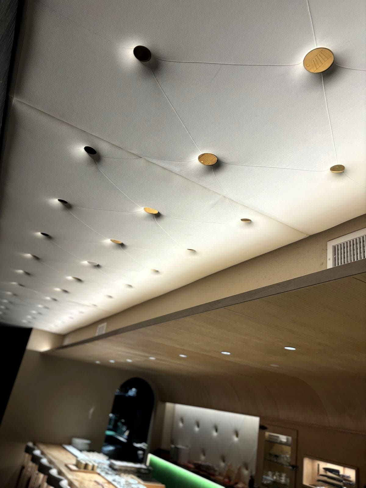 Brass buttons with welded studs for an upholstered wall